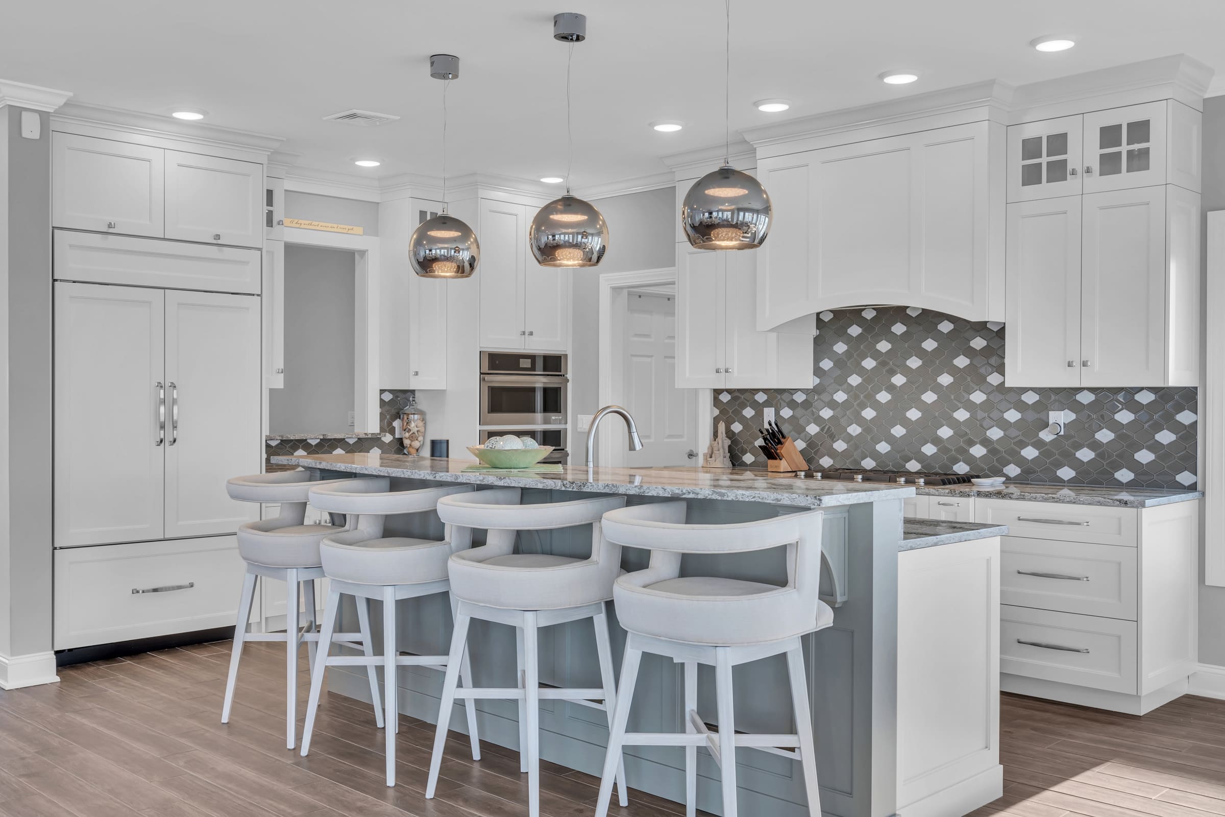 Custom modern kitchen with marble island and pendant lighting in a JJC home